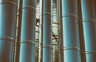 Tall polished process columns rising past an access ladder.