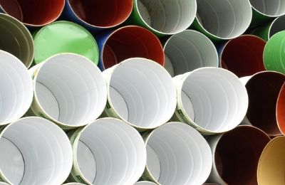 Stacked empty industrial drums seen from above, lined in white, green and red.